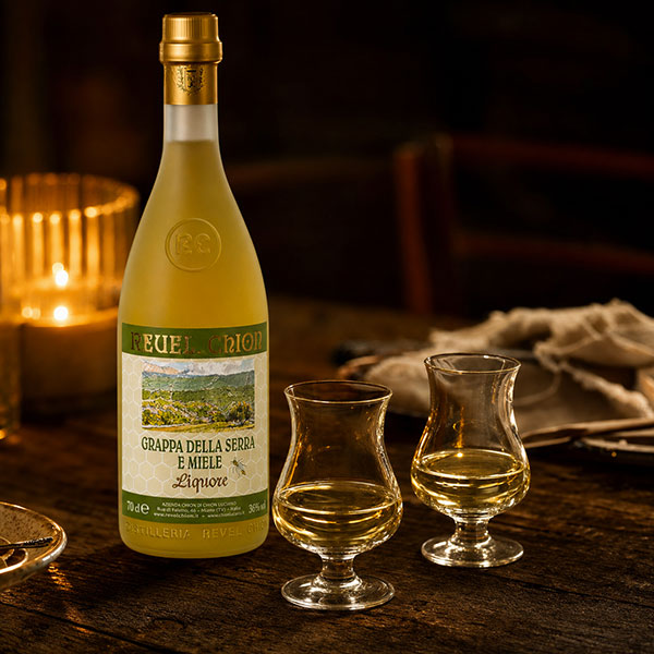 Grappa della Serra al Miele mel — bottiglia con due bicchieri da grappa